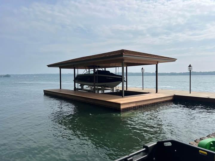 Modern flat-roof boathouse with boat lift and hardwood decking
