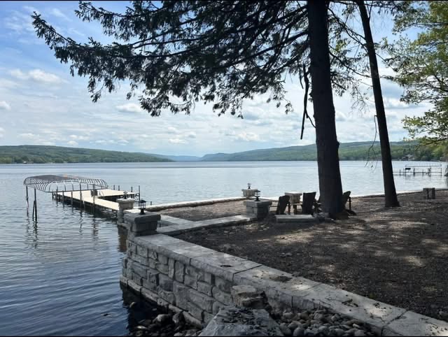 Stone seawall and shoreline patio with dock and boat lift