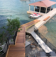 Hardwood deck, stairs and covered boathouse over clear lake water