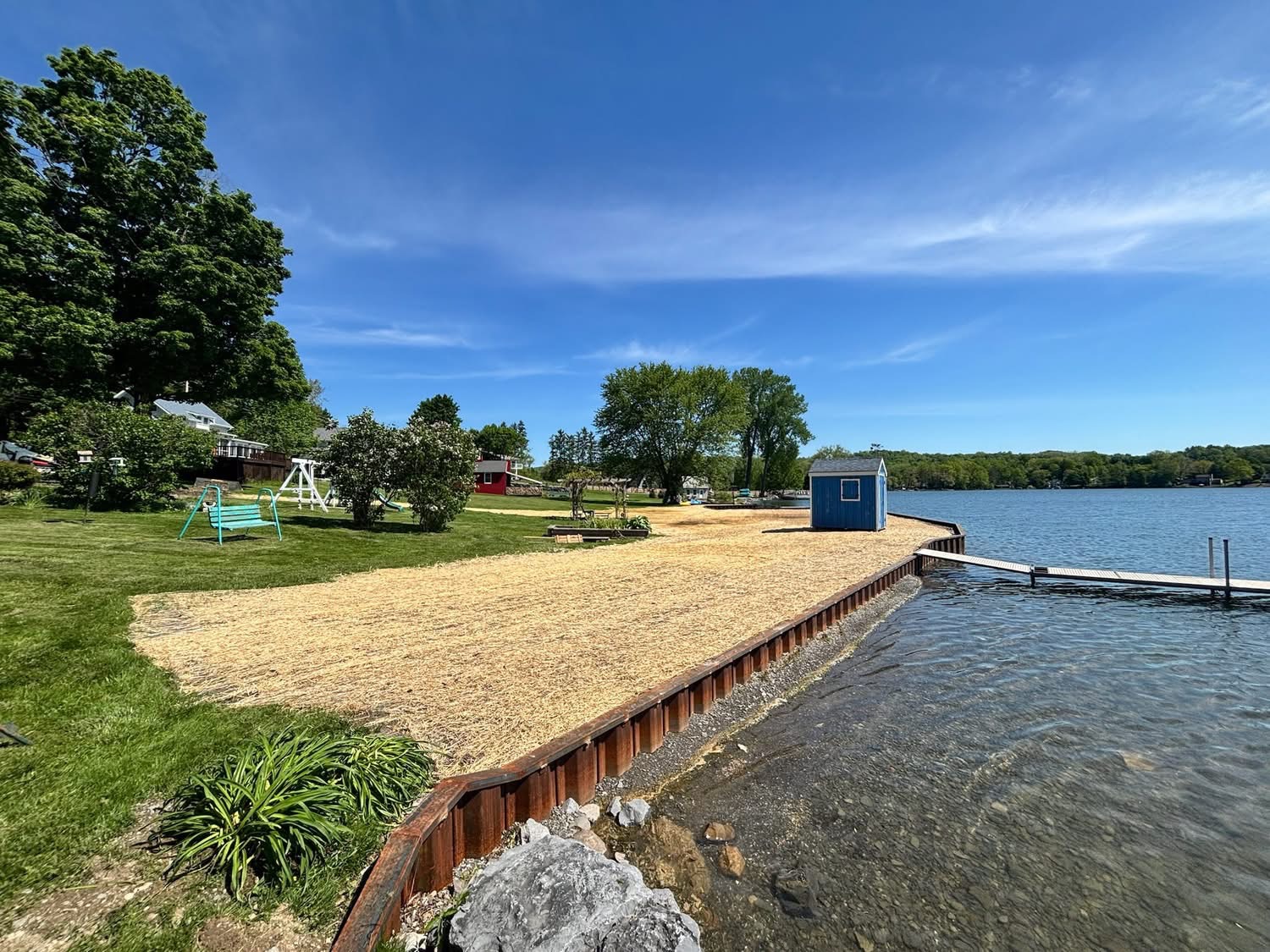 Steel sheet pile seawall with new sand beach, lawn and dock on a lakefront property