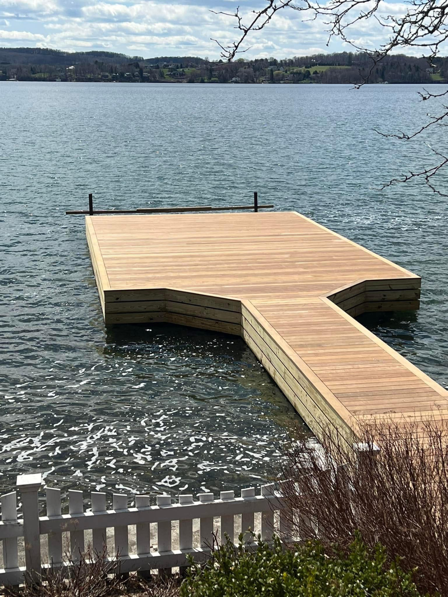 New timber dock with wide platform and walkway extending into the lake
