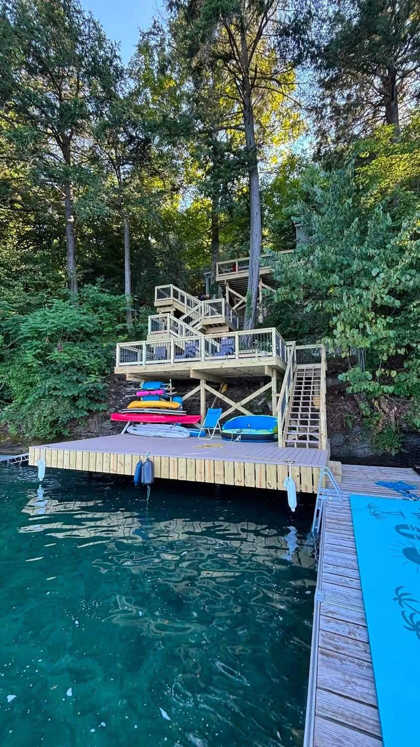 Lakeside deck, stairs and floating dock built into a wooded shoreline