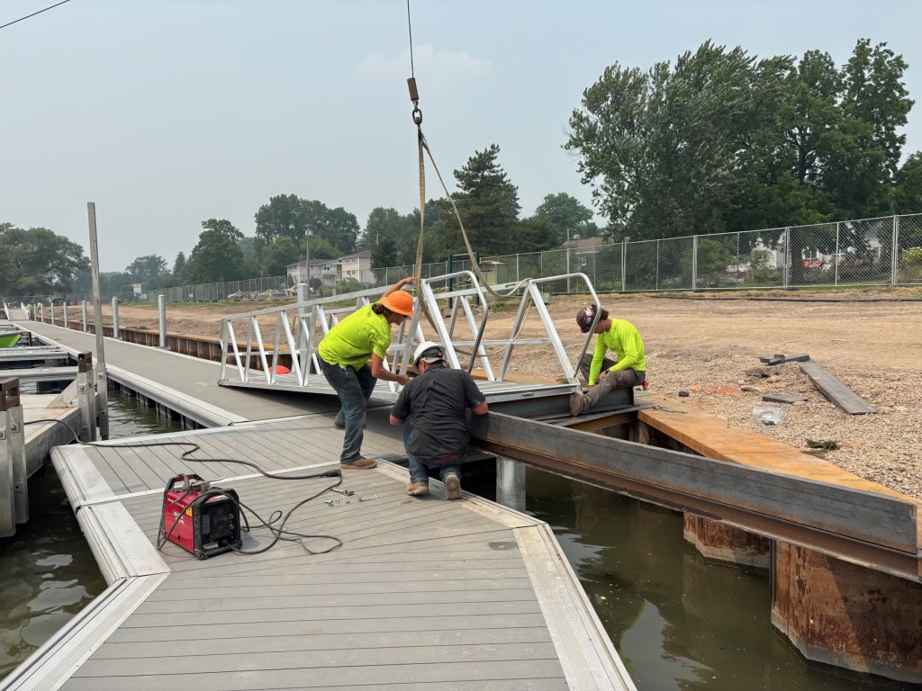 Crew installing an aluminum gangway on a new marina dock system