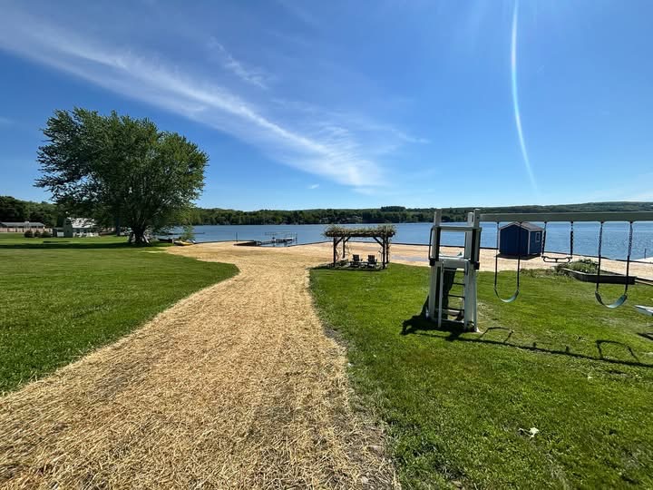 Regraded lakefront lawn with sand beach, pavilion and playground