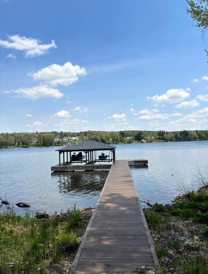 Covered dock pavilion with seating at the end of a long walkway