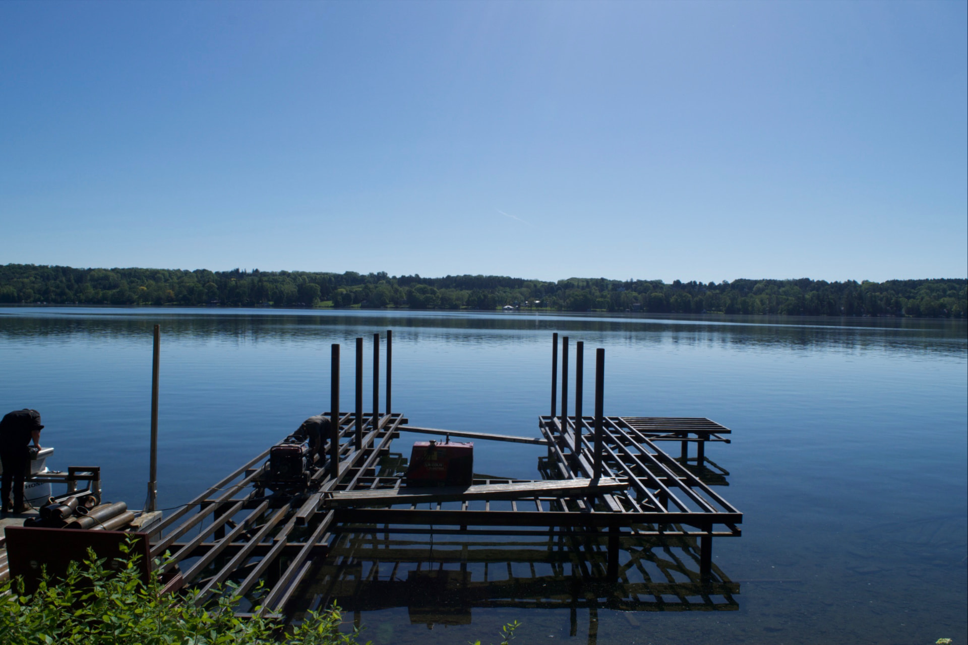 Crew setting steel dock framing and pilings on a Finger Lakes shoreline